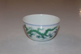 A Chinese tea bowl decorated with dragons, having