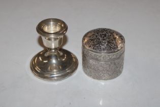 A filled silver candlestick and a white metal box