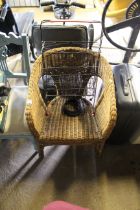 A wicker arm chair and a wire magazine rack