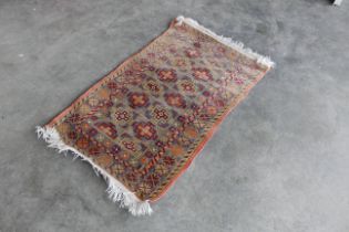 An approx. 4'6" x 2'8" patterned rug AF