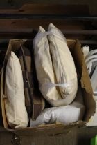 A box containing various cushions, pillows, duvets