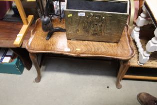 A quarter sawn oak coffee table raised on cabriole