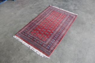An approx. 5'6" x 3'2" red patterned rug AF
