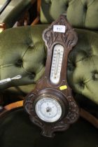 A carved oak cased aneroid barometer and thermomet