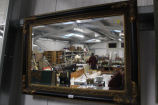 An ornate framed bevel edged wall mirror