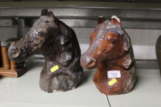 Two concrete ornaments in the form of horses heads