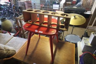 A red painted stool and a small wooden wine rack