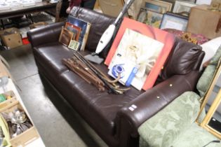 A brown leather upholstered three seater settee