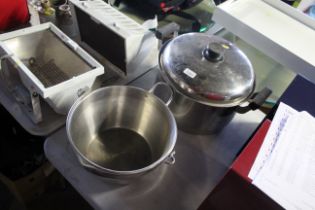 A large metal twin handled cooking pot with lid and a jam pan with swing handle