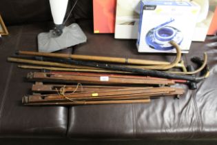 An artists easel and collection of walking sticks