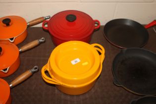 A red Le Creuset casserole dish and a Doufeu yello