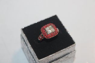 A dress ring set with red and white stones