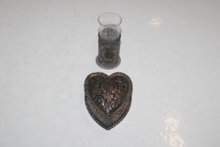A silver heart shaped trinket box with embossed de