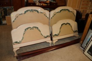 A pair of painted and decorated single beds both w