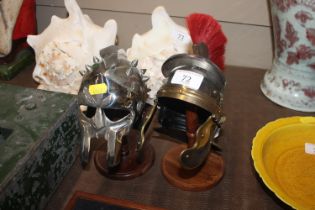 Two miniature Roman helmets on stands