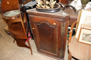 An antique oak hanging corner cupboard