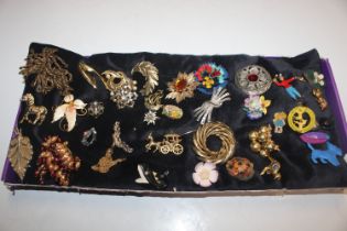 A box of various costume brooches