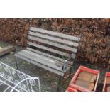 A wooden slated metal framed garden bench with scr