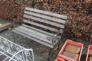 A wooden slated metal framed garden bench with scr