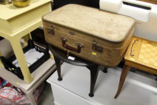 A vintage suitcase and a circular occasional table