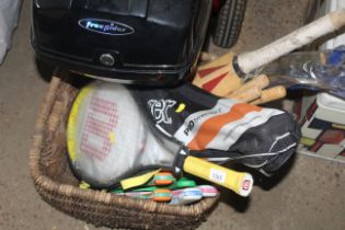 A wicker basket containing various sporting racket