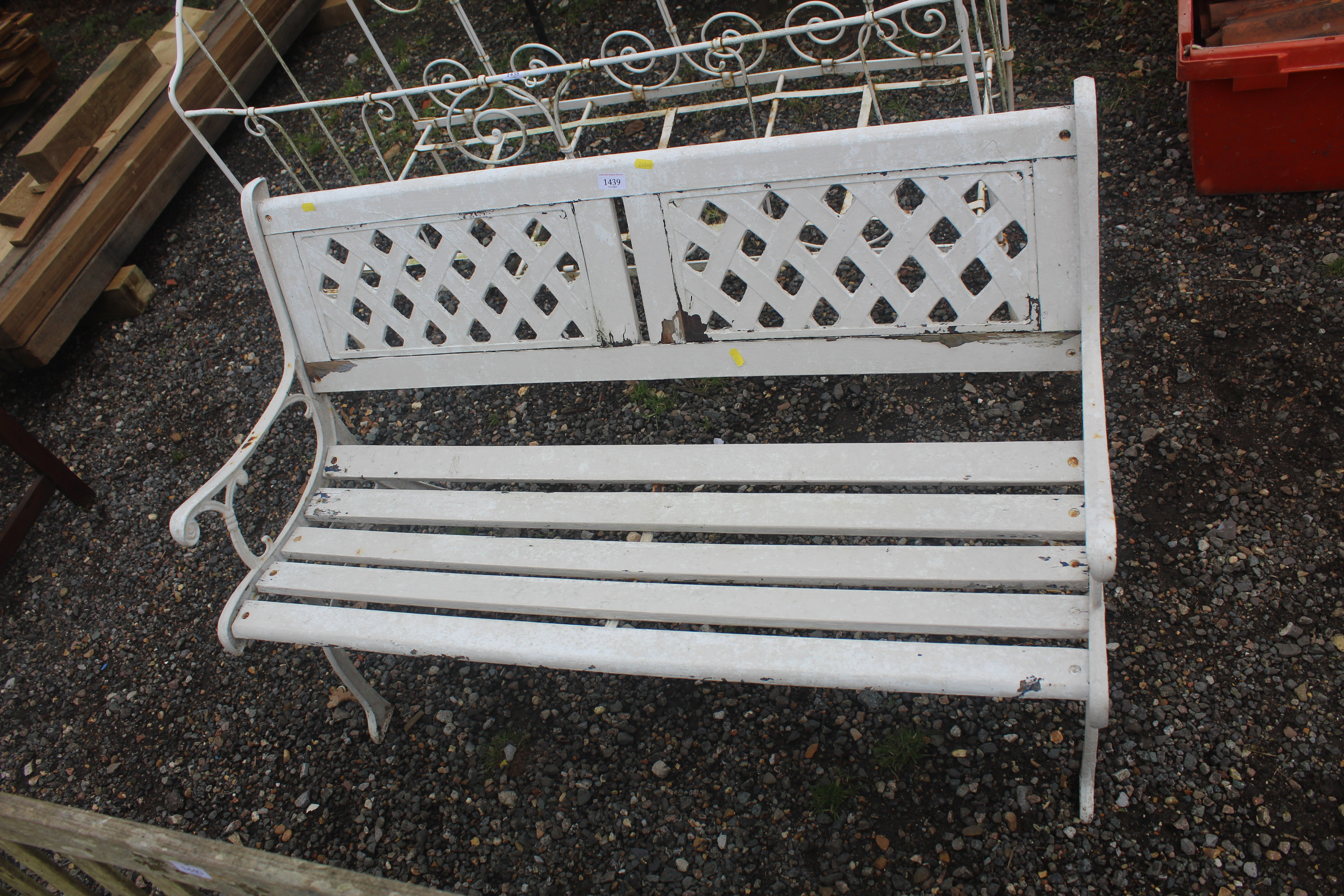 A white painted wooden slated garden bench with ca