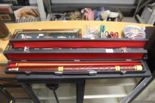 Two two piece pool cues in cases