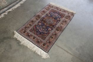 An approx. 5'5" x 2'11" blue floral patterned Turkish rug