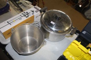A large twin handled cooking pot with lid and a ja