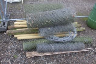 A quantity of fencing posts and rolls of used chic