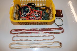 A box of jewellery including various bangles and bead necklaces