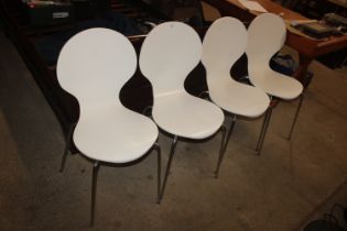 A set of four white dining chairs in the manner of
