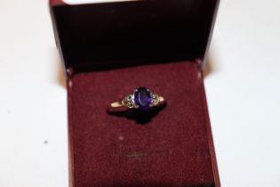 A 9ct gold ring set with amethyst coloured stone a
