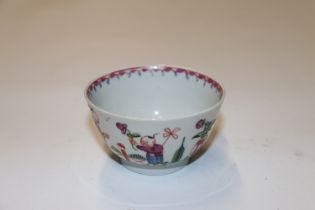 An oriental tea bowl decorated with figures