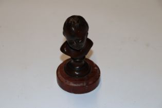 A small bronze bust raised on rouge marble base