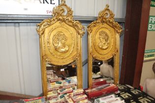 A pair of decorative bevelled edged gilt framed wa