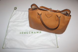 A Longchamp tan leather handbag and dust cover