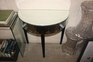 A mirrored demi lune console table