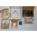 A wooden jewellery box with contents of various co
