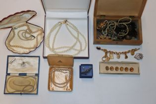 A wooden jewellery box with contents of various co