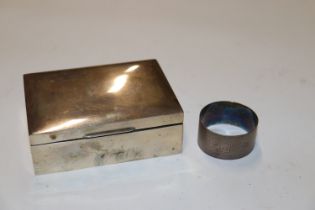 A silver cigarette box and a silver napkin ring ap