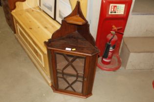 A small mahogany corner cupboard with glazed door