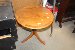 A reproduction yew wood circular topped side table
