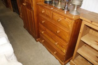 A pine chest of drawers comprising two short over