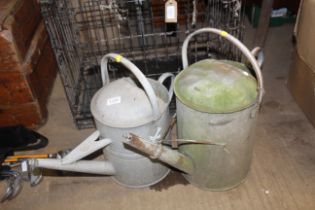 Two galvanised watering cans lacking roses