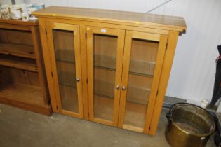 A large modern oak display cabinet with two internal