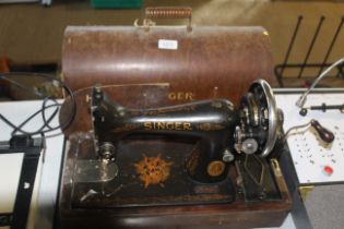 A Singer hand sawing machine in wooden case