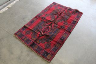 An approx. 5'2" x 3'1" baluchi patterned rug