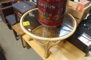 A cane and smoke glass topped circular table