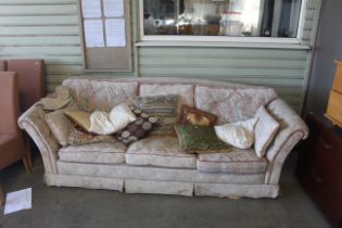 An upholstered three seater settee with loose cush